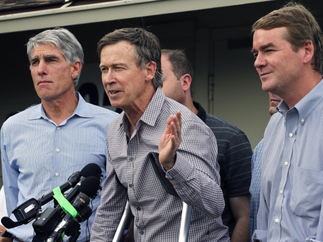 Colorado Gov. John Hickenlooper (center) speaks to members of the media Saturday, alongside Sens. Mark Udall (left) and Michael Bennet, after touring flood-damaged areas by army helicopter.