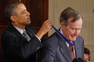 President Barack Obama (L) presents former U.S. President George H.W. Bush with the 2010 Medal of Freedom in the East Room of the White House February 15, 2011 in Washington, D.C. Obama presented the medal to twelve pioneers in sports, labor, politics and arts.