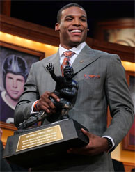 Auburn quarterback Cam Newton picks up the Heisman Trophy after his acceptance speech. Newton's father has been accused of trying to solicit Mississippi State for money in exchange for his son's athletic service.