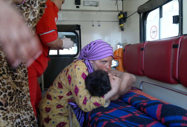 A woman embraces an injured Syrian boy i