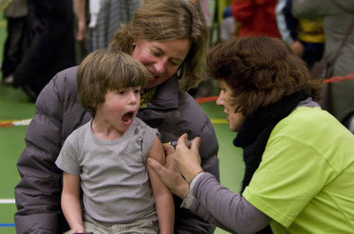 A child expresses his discomfort as he's given a shot.