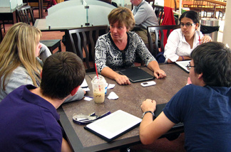 Clockwise from far right, students Salma Makkar, Thomas Pacheco, Cameron Akers and Jennifer Tonti talk with teacher Nancy Boyle, center, in Cushing Academy's new bookless library.