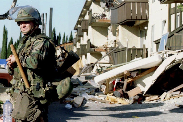 A National Guardsman stands guard outside the ruin