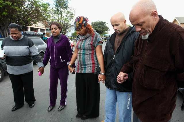 Neighbors, led by Pastor Joyce Williams, second from left, prayed last Wednesday outside the home where a mother allegedly drowned her 1-year-old and attempted to drown her 5-year-old daughter.