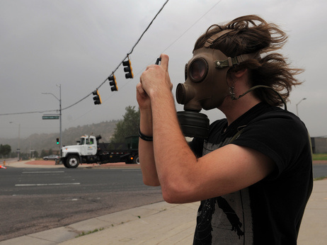 Mikke Carlson took photos of the smoke from the Waldo Canyon fire while wearing a gas mask on Wednesday, June 27, 2012, in Colorado Springs, Colo.