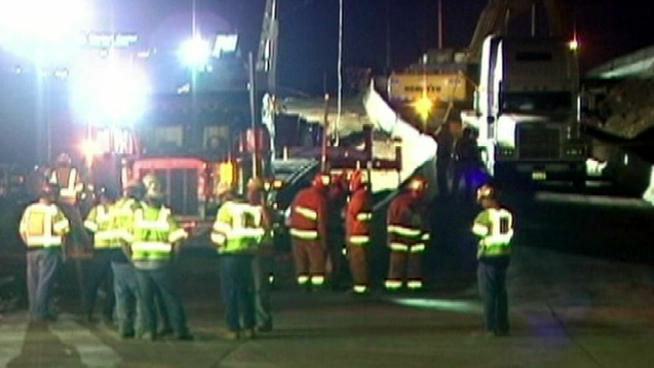 Workers and rescuers at the site of a fatal construction accident on the 405 Freeway.