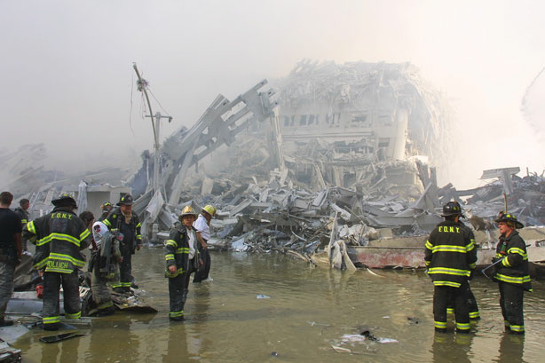 New York City firefighters work at the World Trade Center after two hijacked planes crashed into the Twin Towers September 11, 2001 in New York.