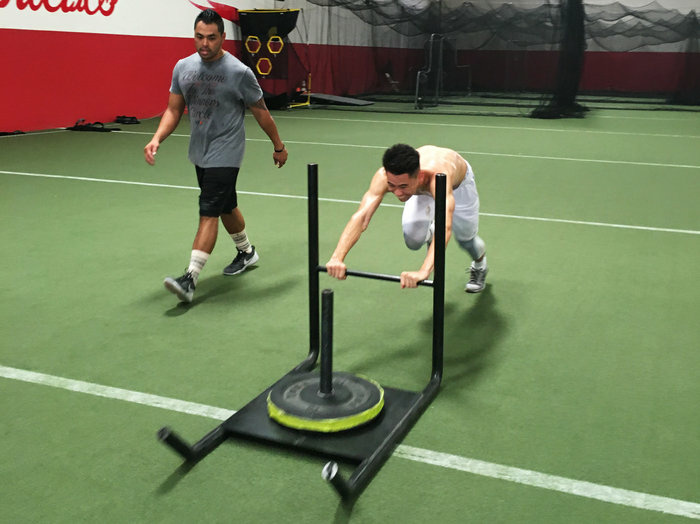 Badminton player Howard Shu pushes a weight sled designed to help improve his speed and explosive power on the court. Shu, 25, of Anaheim, Calif., will be the sole U.S. men's singles player in badminton at the Olympics.