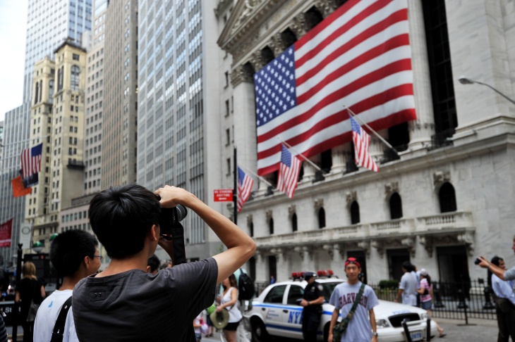 Tourists pose for photographs in front o