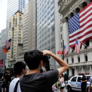 Tourists pose for photographs in front o