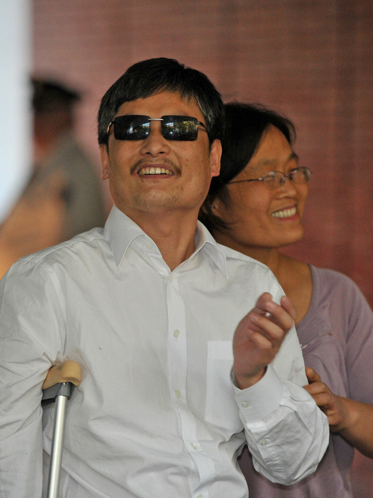 Chinese activist Chen Guangcheng and his wife Yuan Weijing arrive at an apartment complex in New York on Saturday.