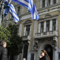 People walk by a National Bank of Greece