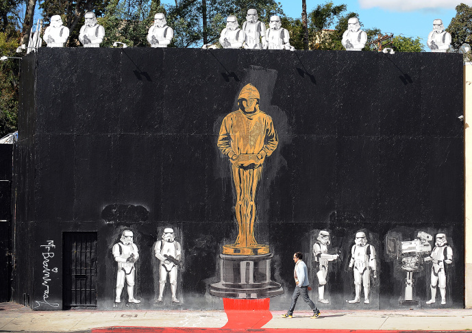 A man walks in front of a mural celebrat