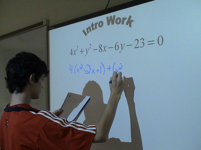 File: A student writes on a Smart Board.