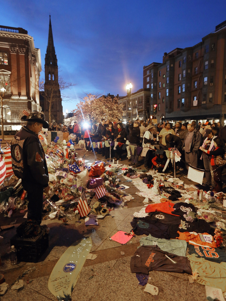 People gather at a makeshift memorial for victims of the Boston Marathon bombings. The surviving suspect in the case, Dzhokhar Tsarnaev, remains in the hospital. His older brother, also a a suspect, was killed by police. The brothers are from an immigrant family with roots in the former Soviet Union, and this has stoked debate as the Senate contemplates an immigration reform bill.