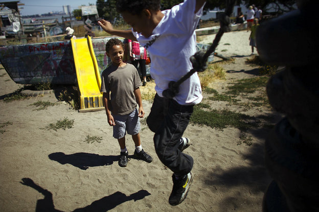 Deion Jefferson, 10, and Samuel Jefferson, 7, take turns climbing and jumping off a stack of old tires at the Berkeley Adventure Playground in California. The playground is a half-acre park with a junkyard feel where kids are encouraged to "play wild."