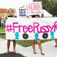 Supporters stand near the street holding