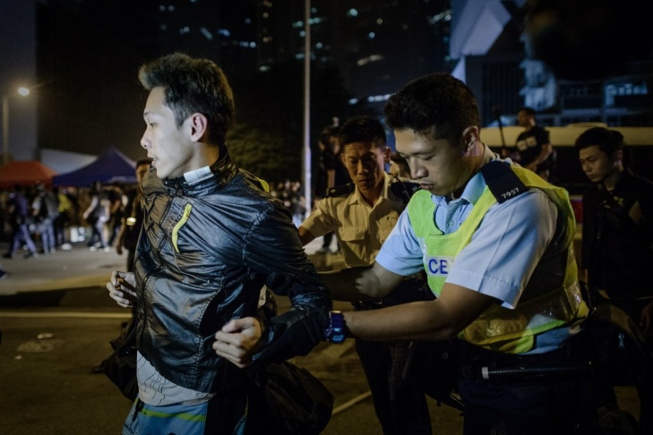 Police force arrest a pro-democracy protester in Hong Kong