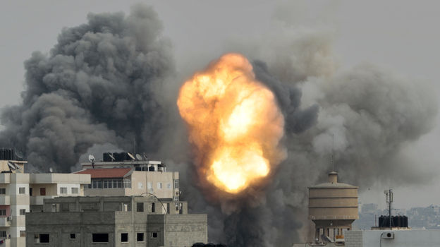 In Gaza City today, flames and smoke rise from the site hit by an air strike from Israeli forces.