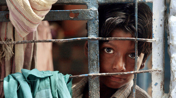 A street child looks out from his classroom during studies conducted by the Salaam Baalak Trust at the New Delhi railway station in September 2004. Salaam Baalak Trust is an Indian charity for homeless children.