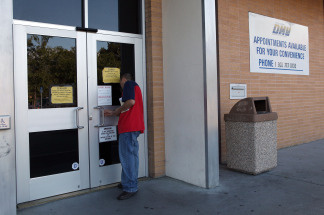 A California Department of Motor Vehicles customer peers into the door of a closed DMV branch July 10, 2009 in Corte Madera, California. The state Department of Motor Vehicles has released proposed regulations listing the kinds of documents that would be acceptable for unauthorized immigrants to use in order to apply for a special driver's license, set to become available in January.