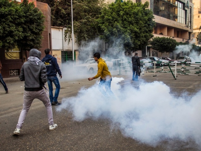 Anti-military protesters run away from tear gas fired by riot police near the Ramsis square, downtown Cairo, Egypt, on Saturday.
