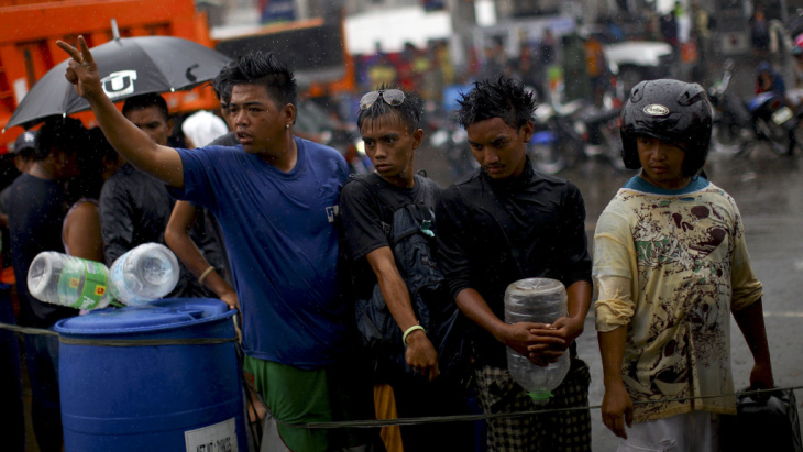 Filipino men stand in line to fill containers with gas in Tacloban, Philippines, on Sunday. The area experienced widespread gas shortages in the wake of Typhoon Haiyan.