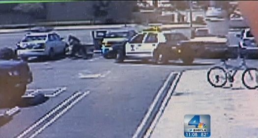 A screenshot from NBCLA shows an arrest in a parking lot in which an officer wrestles a driver to the ground.