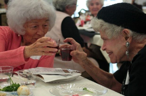 Betty Uchida and Lucille Weiss clink glasses during the Seder ritual in Boyle Heights, April 2, 2012