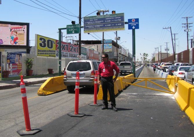 A tourism official stands in front of the new designated medical tourism lane at the Mexicali border crossing.