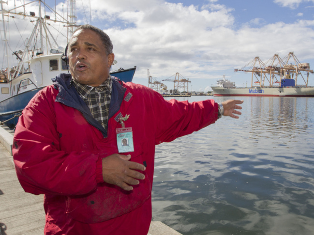 John Hernandez of Kailua, Hawaii and owner of John's Fresh Fish, is shown on Thursday. In the background at right is a container ship owned by Matson. A pipe maintained by the company cracked and caused the molasses spill.