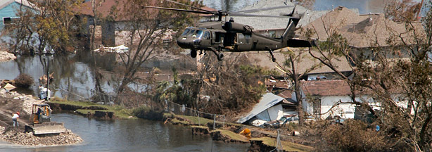 A helicopter lowers sandbags to fill the gap left behind the 17th Street levee failure.