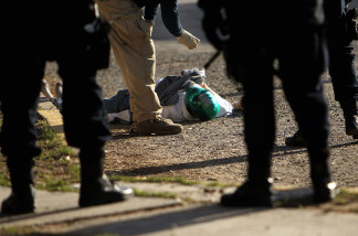 A criminal investigator takes pictures of a body in Juarez, Mexico. The border city of Juarez, Mexico has been racked by violent drug related crime recently and has quickly become one of the most dangerous cities in the world to live.