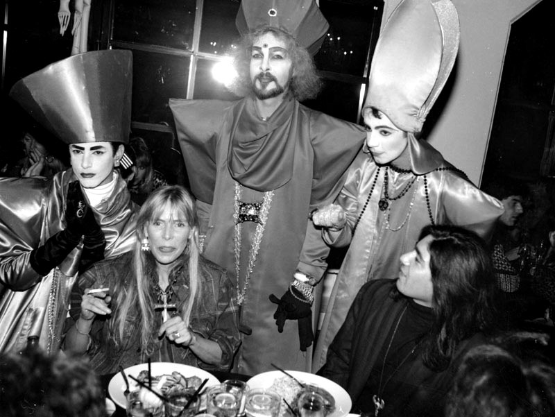 Joni Mitchell seated beside poet Joaquine. Standing behind are the Voguing Popes: Bret Boreman, Steven Arnold and J.V. McCuley.