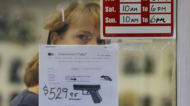 A clerk peers out from a gun shop in Seattle on Wednesday.