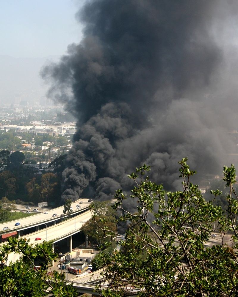 Smoke billows from a fire Saturday July 13, 2013 in Los Angeles, after a tanker truck flipped, spilled its load of gasoline and caught fire, snarling traffic for miles.