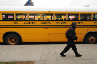 A student on his way to school walks past a Los Angeles Unified School District (LAUSD) school, in Los Angeles, California on February 13, 2009.