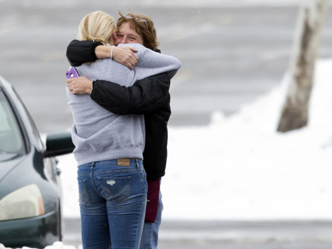 Two people embrace in the parking lot at the scene of a shooting at The Mall in Columbia on Saturday, in Columbia, Md.