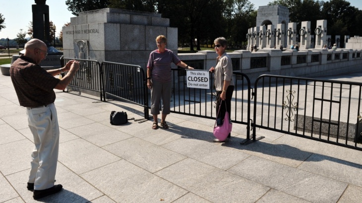 On the sixth day of a federal government shutdown that has barricaded national parks and attractions, tourists take photos at the World World II Memorial in Washington Sunday.