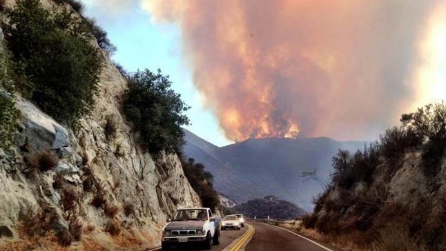 Flames from the Falls Fire in Riverside rise above a mountain on Aug. 5, 2013.