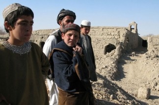 Children stand on the ruined wall of a house in a hamlet in Lower Khasro, Arghandab.