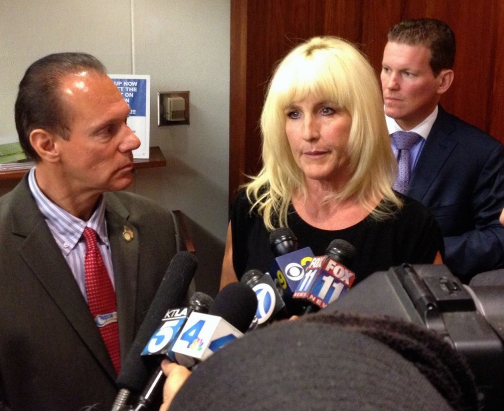City of Carson Mayor Jim Dear listens as Erin Brockovich speaks to media after Carson declared a local emergency over Carousel neighborhood contamination. Brockovich works with the law firm Girardi & Keese, which is representing Carousel residents.