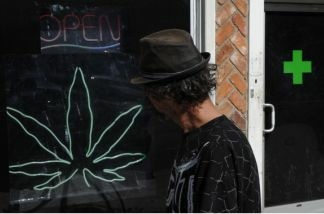 A man walks past a medicinal marijuana dispensary in Los Angeles, CA on November 2, 2010. Although voters rejected Prop 19, marijuana will still be legal for medical users.
