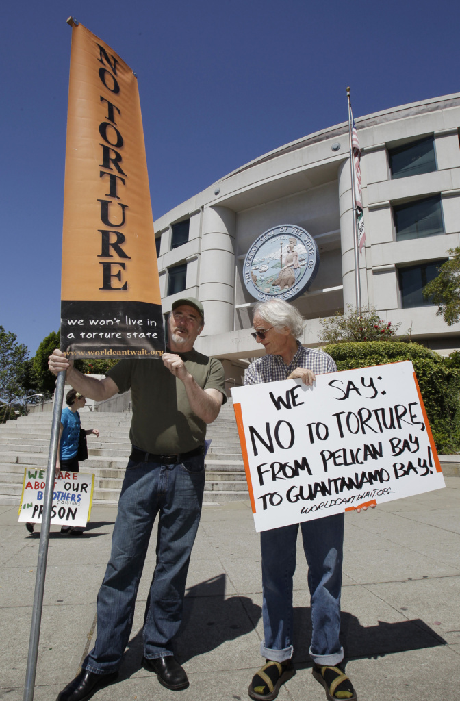 Demonstrators hold up signs during a rally in front of the State Building in San Francisco, Friday, July 1, 2011 to support prisoners at Pelican Bay State Prison.