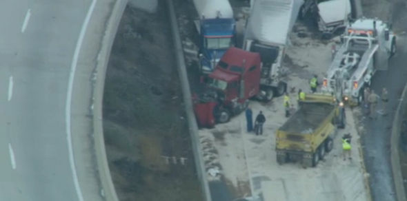 Crews work to clean up an accident involving nine big rigs on southbound Interstate 5 at the truck bypass tunnel at Newhall Pass north of Los Angeles early Tuesday morning.