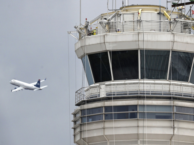 A passenger jet flies past the FAA control tower at Washington's Ronald Reagan National Airport.