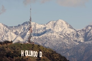 The Hollywood sign and the undeveloped land that surrounds it are seen against the snow-covered San Gabriel Mountains.