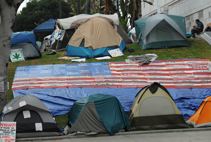 A demonstrator sits outside a tent at the Occupy L.A. encampment in downtown L.A.