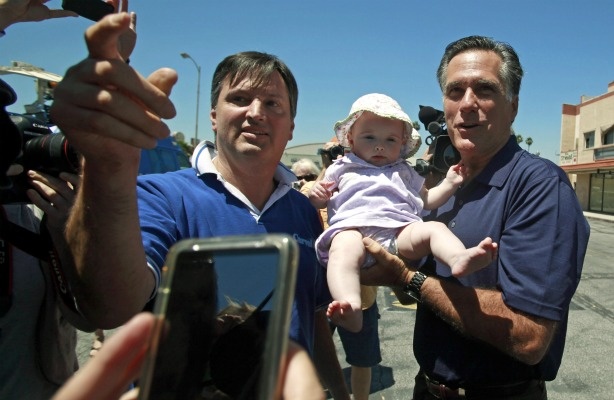 Republican 2012 presidential hopeful, former Gov. Mitt Romney of Massachusetts, poses with Stephen Winnick and his 7-month-old daughter Sarah before a news conference at a mostly-empty shopping center in the North Hollywood area of Los Angeles on July 20, 2011.