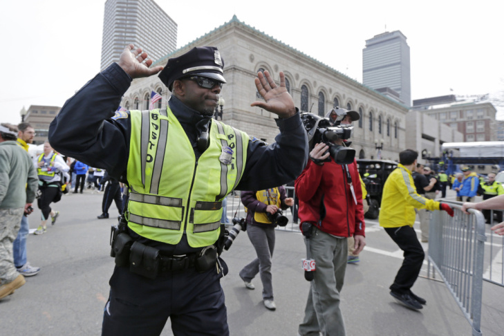 A Boston police officer clears Boylston Street following the explosions.